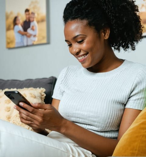 A single parent gracefully balancing family responsibilities and dating life, checking their phone while engaging with their children in a comfortable home setting, symbolizing harmony between personal growth and family well-being.